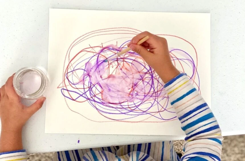 Child makes marks and uses water to explore what happens