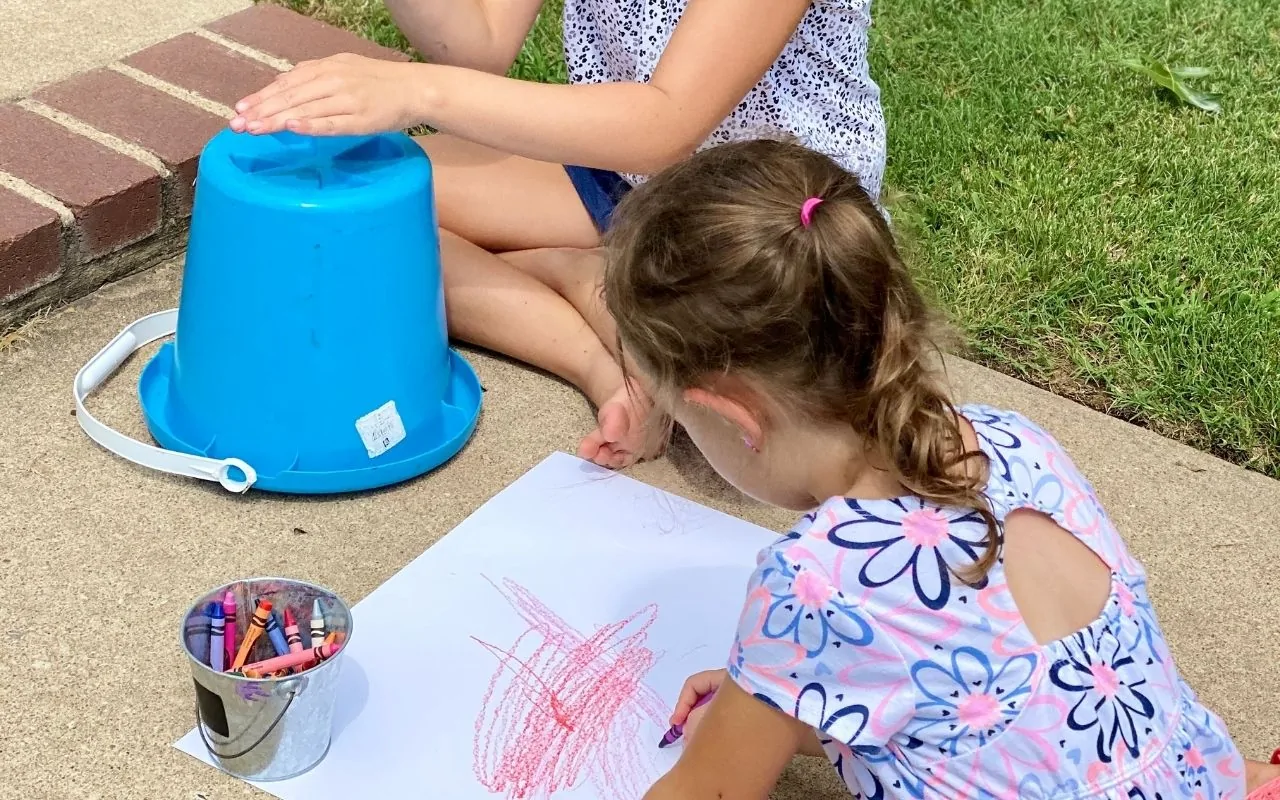 Children drawing with crayons to the beat of the drum
