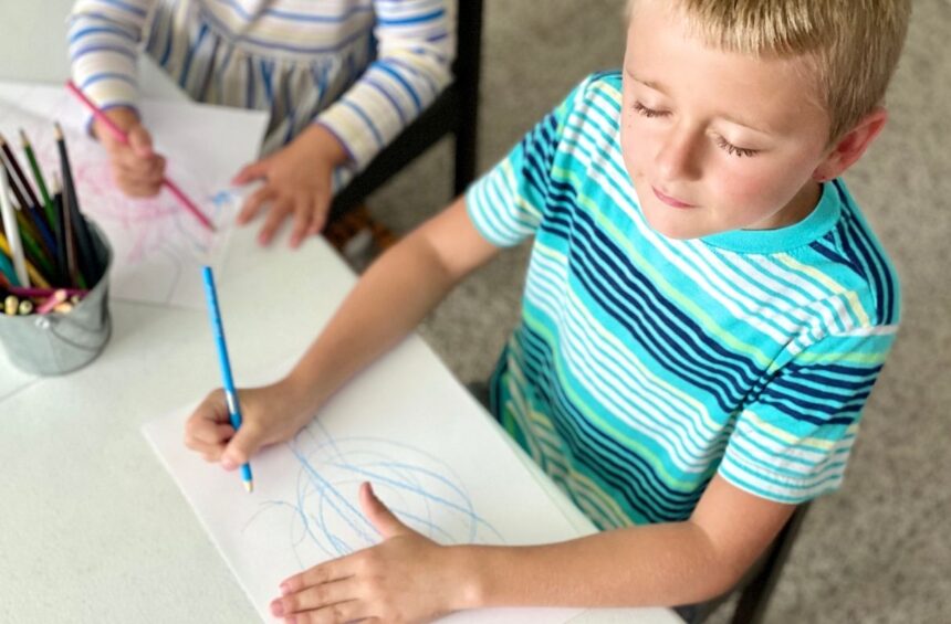 Child makes marks while closing eyes