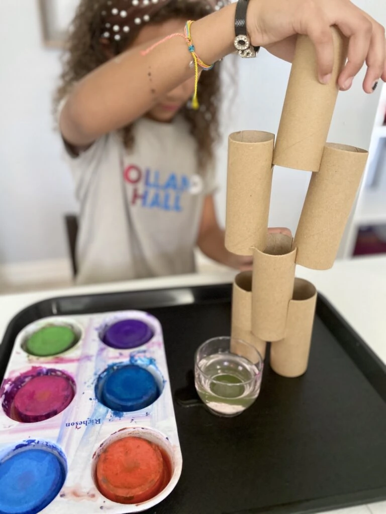 Child painting paper tubes built up like a sculpture