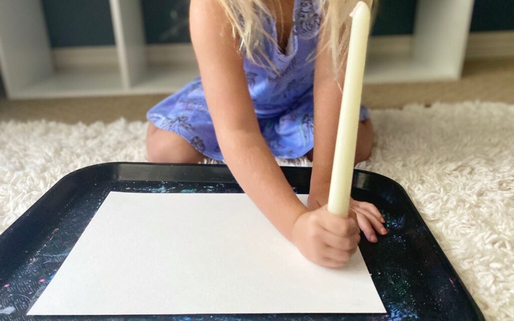 Child drawing with a candlestick