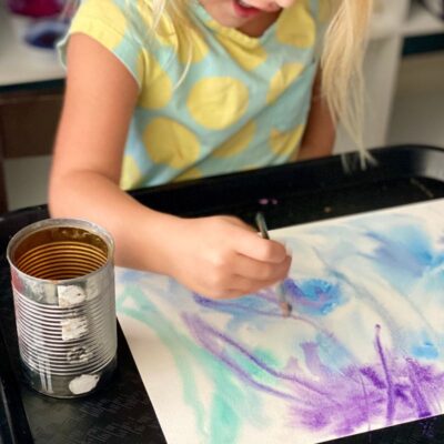 Child painting on top of wet paper