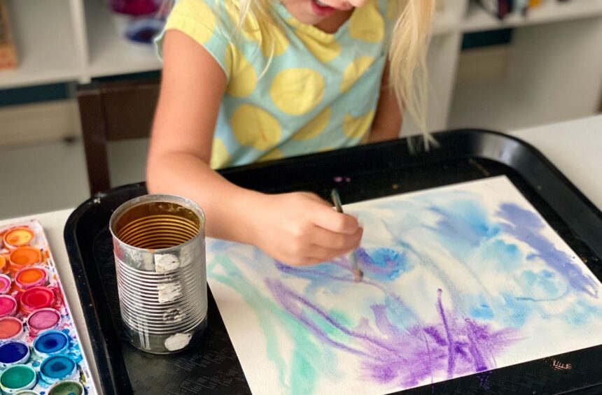 Child painting on top of wet paper