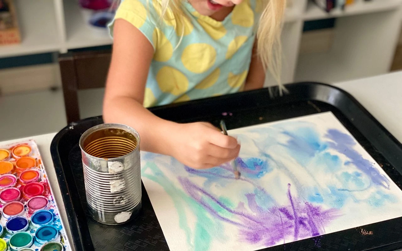 Child painting on top of wet paper