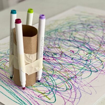 Markers attached to cardboard tube with tape for children to make marks