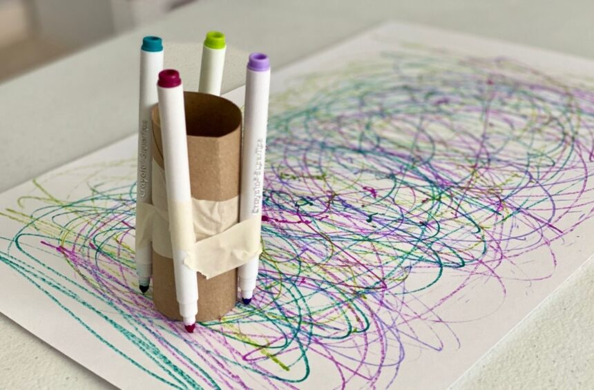 Markers attached to cardboard tube with tape for children to make marks