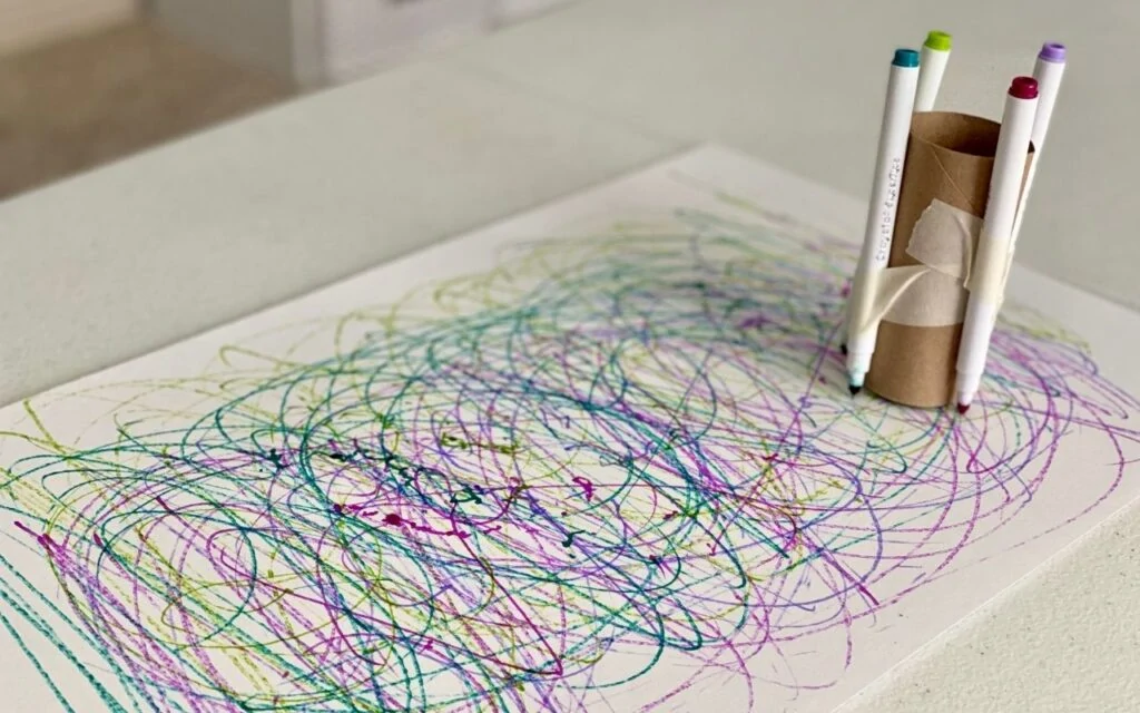 Scribble marks from markers attached to cardboard tube