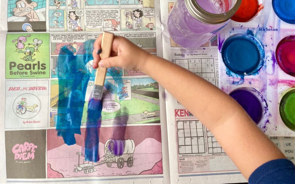 Child painting on newspaper