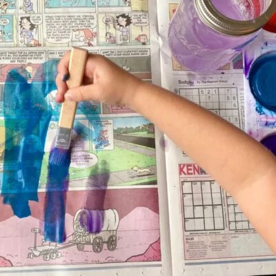 Child painting on newspaper
