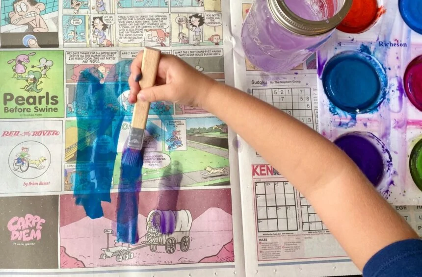 Child painting on newspaper