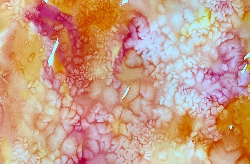 Child experimenting with liquid watercolor paint and rice on paper