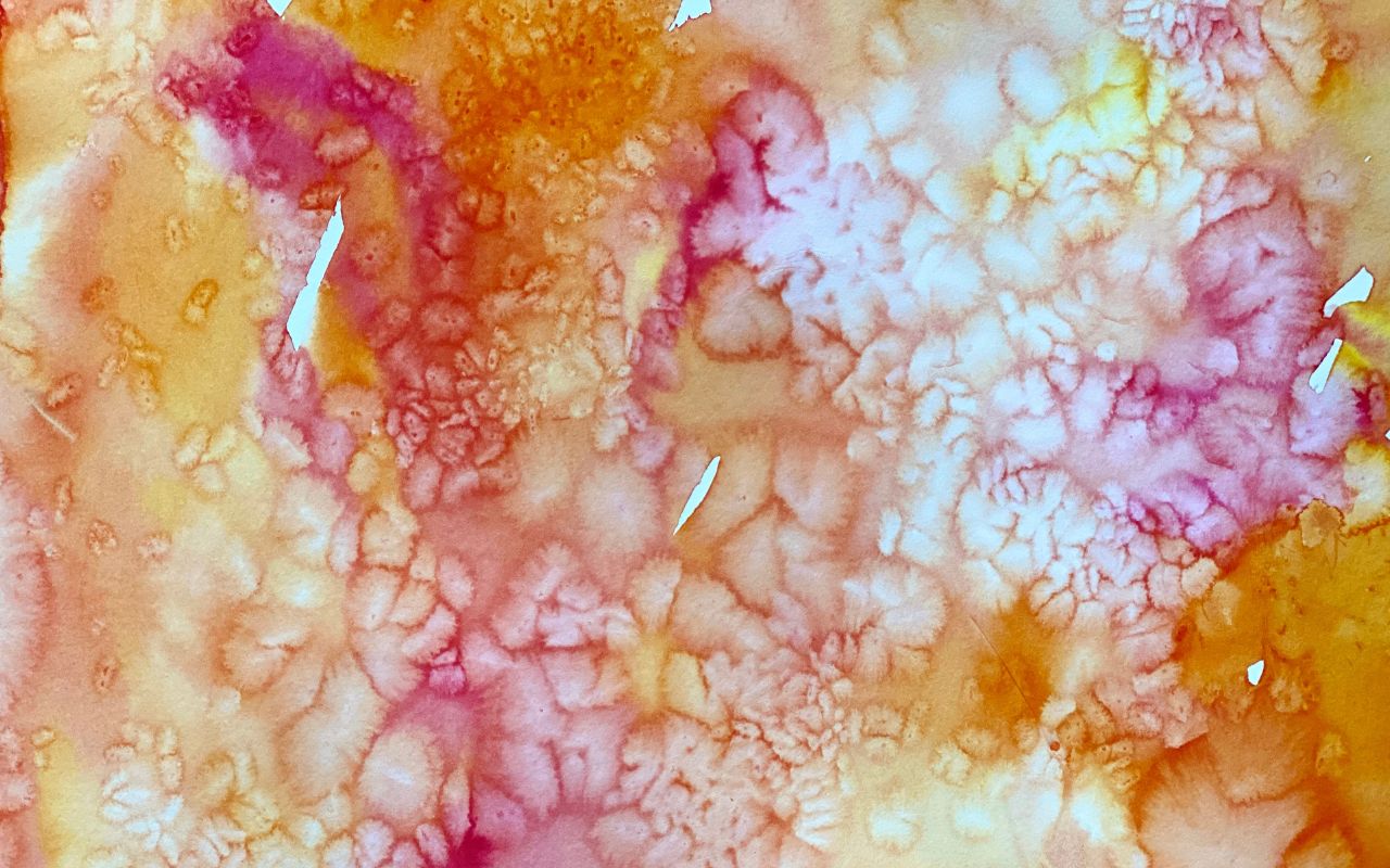 Child experimenting with liquid watercolor paint and rice on paper