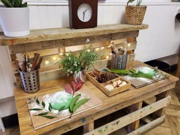 green playdough with large leaves set on a wooden pallet desk