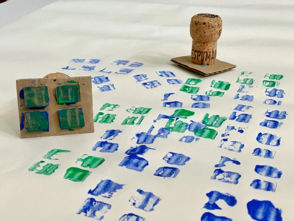 Children stamping with cardboard stamps and tempera paint