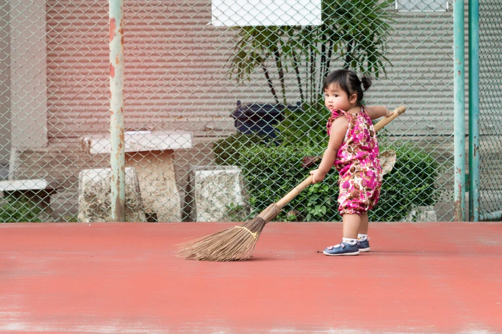 Phases of play: Child sweeping floor in an imitation phase of play