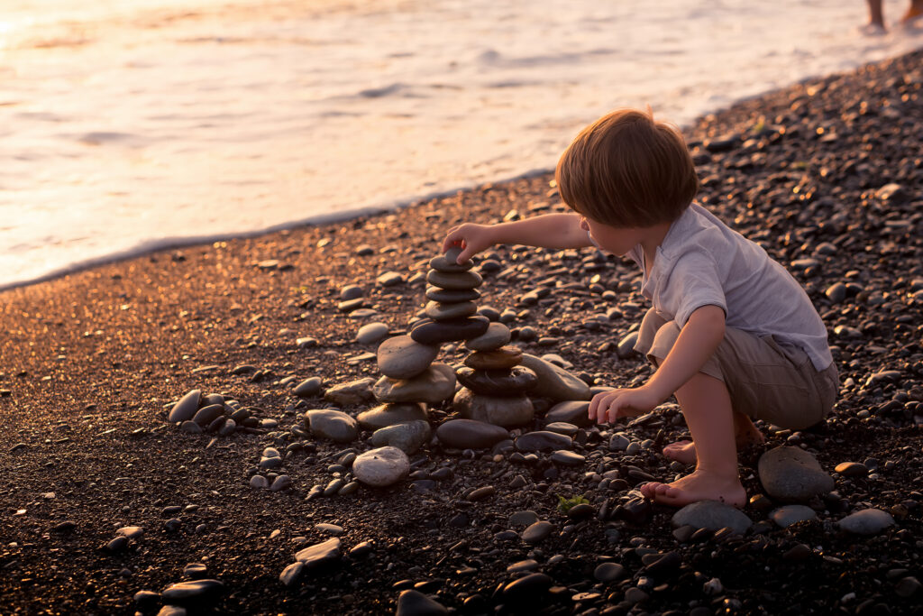 Phases of play: Child stacking stones in an usage exploration phase of play