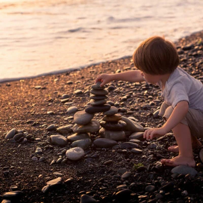 Phases of loose parts play: Child stacking stones in an usage exploration phase of play