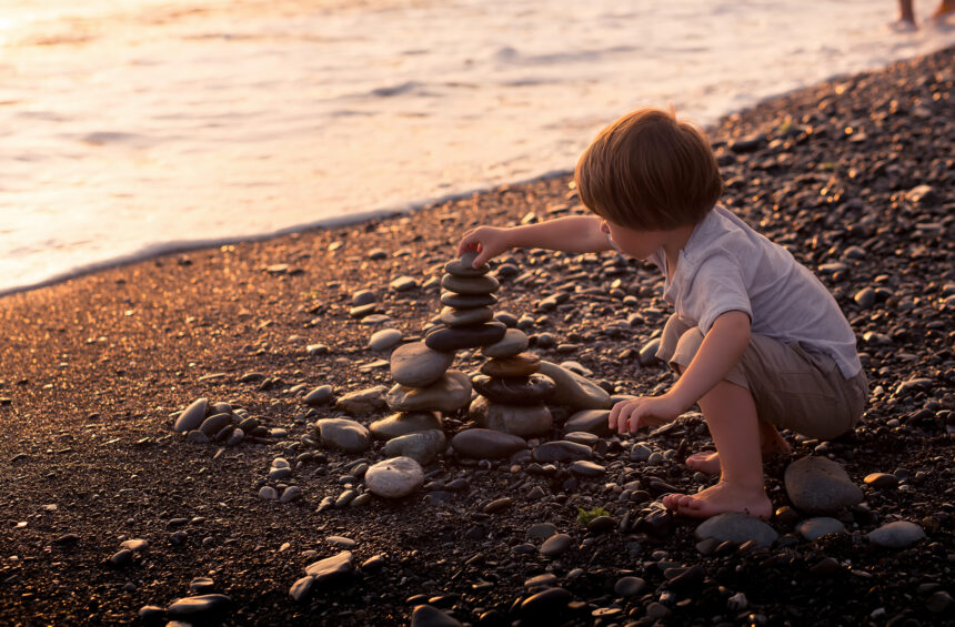Phases of loose parts play: Child stacking stones in an usage exploration phase of play