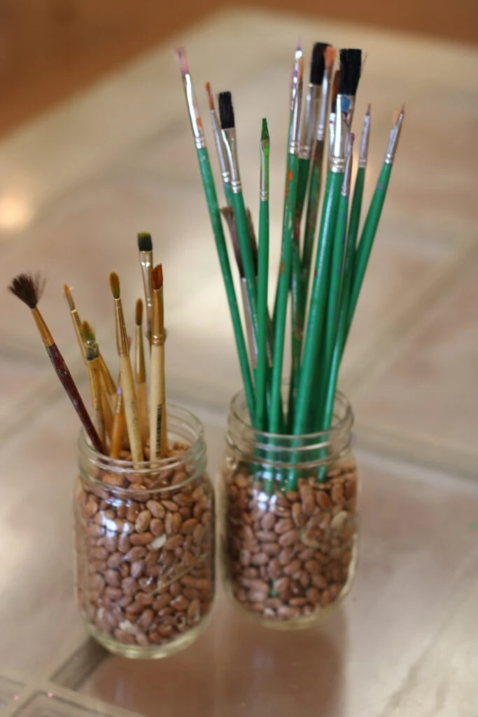 Jars with beans or gravel for displaying paintbrushes