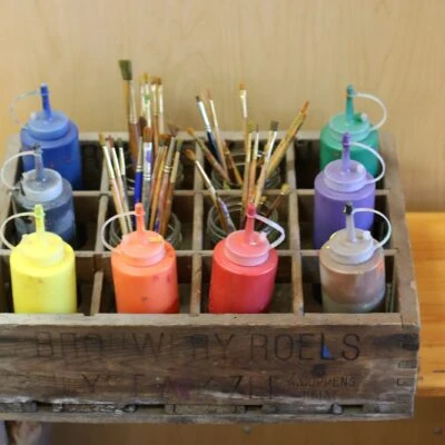Classroom storage solutions bottles of paint in a wood crate