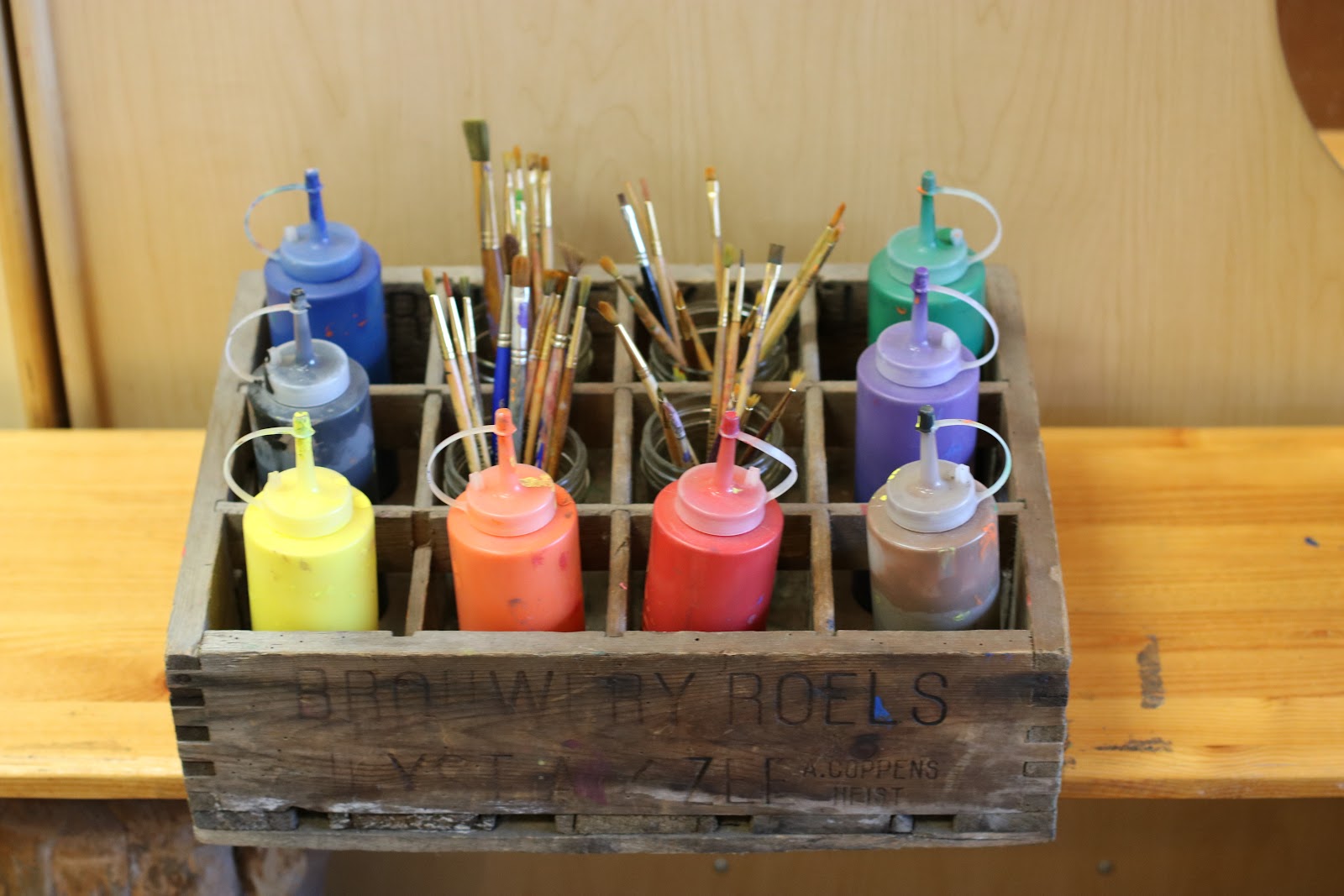 Classroom storage solutions bottles of paint in a wood crate